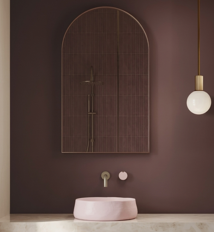 Modern bathroom with a pink sink, mirror, and pendant light on a dark purple wall.